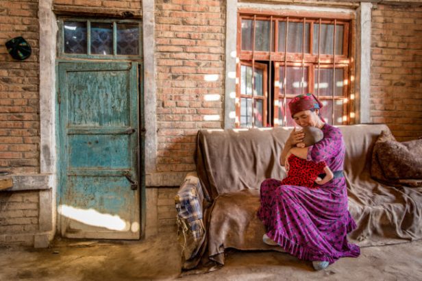 cina, una donna e un bambino  seduti su un divano nel cortile de